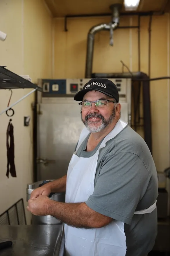 Pat Sommers at the grinder in his apron